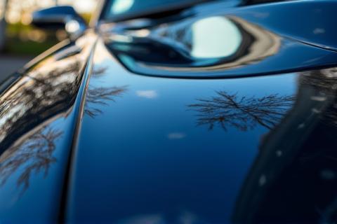 A close-up view of a car's paintwork after polishing, demonstrating a mirror-like shine and smooth finish.
