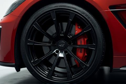 A spotless car wheel and tire after deep cleaning, highlighting restored black tire shine and clean rims.